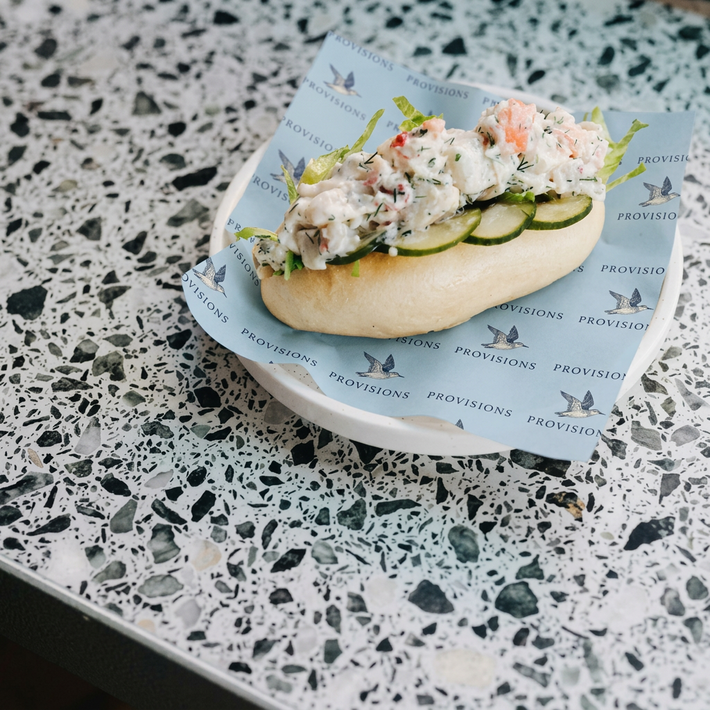 Filled roll served on powder blue Provisions deli paper